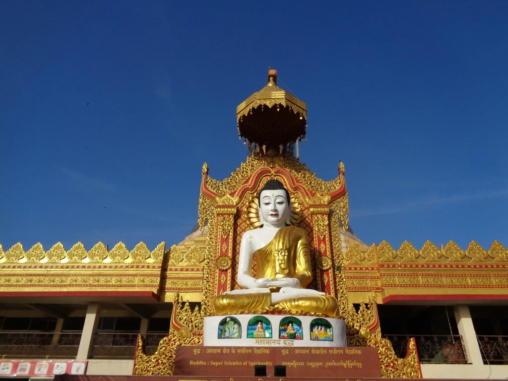 Magnificent golden Buddha statue at a decorated temple entrance in full daylight