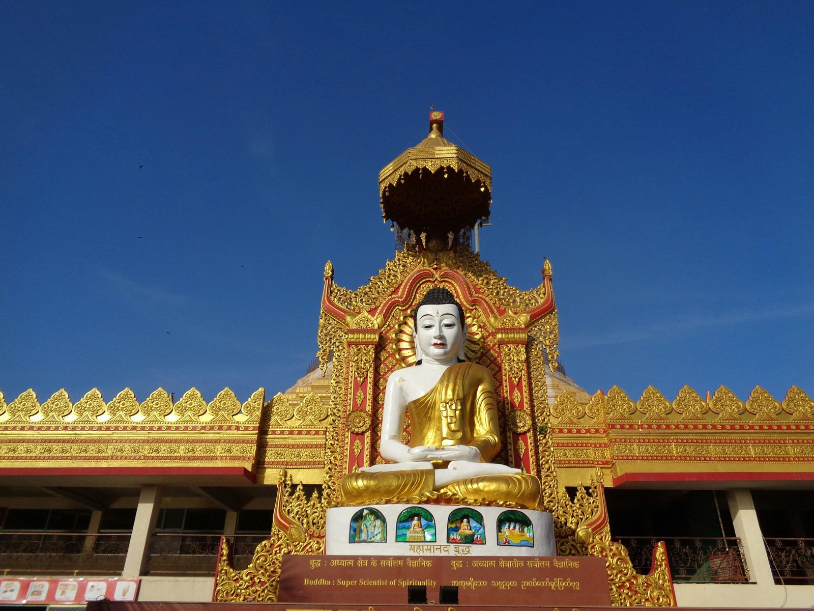 Magnificent golden Buddha statue at a decorated temple entrance in full daylight