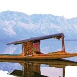 A vibrant shikara on Dal Lake with the stunning Himalayan backdrop, perfect for travel exploration.